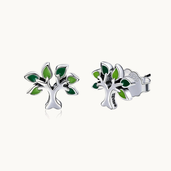 Une paire de boucles d'oreilles est exposée devant un fond beige.  Ce sont des boucles d'oreille en forme d'arbre de vie. Les feuilles sont colorées. Elles sont en argent 925.