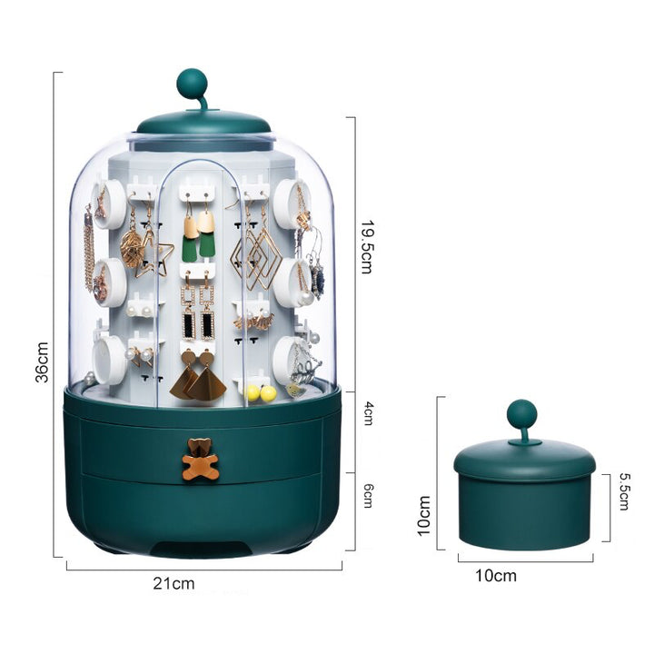 Un présentoir rotatif à 360° pour boucles d'oreille avec boîte de rangement. Design élégant et fonctionnel avec tiroirs charmants et ourson doré.