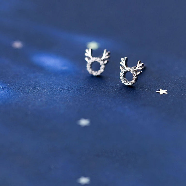 Une paire de boucles d'oreille argent avec diamants, ornées de strass scintillants en forme de renne - Enfant - Argent 925. Idéales pour les festivités de Noël.