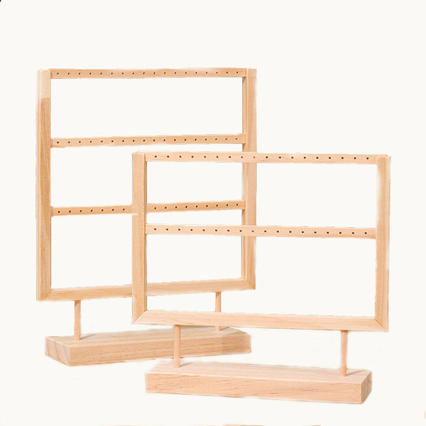 Ce sont deux présentoirs à boucles d'oreille en bois. Il y en a un qui a deux rangées et l'autre trois. Ils sont rectangulaires.