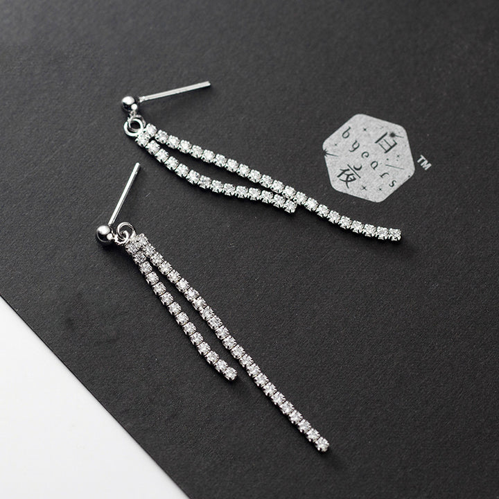 Boucle d'oreille pendante avec lignes de diamants en zirconium et boule d'argent 925. Élégance et raffinement pour toutes occasions.