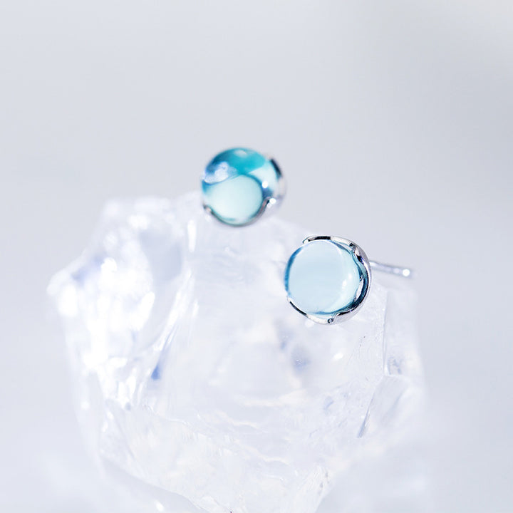 Boucle d'oreille ronde cristal bleu clair - Femme - Argent 925, sur glace. Un bijou lumineux et charmant, parfait pour une élégance quotidienne ou une tenue de soirée.