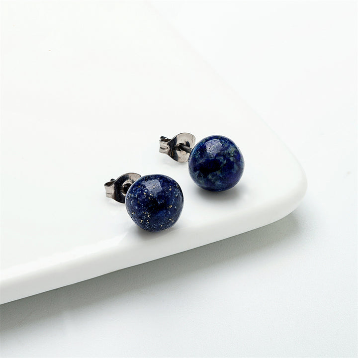 Boucle d'oreille acier chirurgical pierre ronde bleue - Homme. Élégantes boucles d'oreille en titane hypoallergénique avec pierre Lapis lazuli bleue, symbole de puissance et noblesse. Allure virile et vibrante pour toute tenue. 6 mm, 8 mm. 4g.