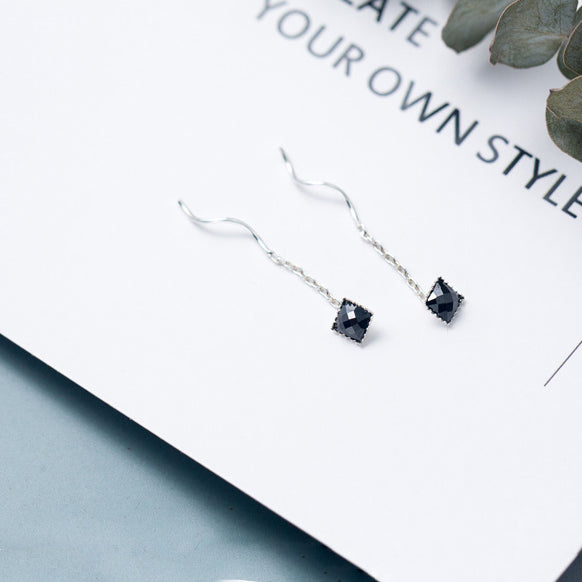 Boucle d'oreille pendante argent 925 avec obsidienne noire carrée et chaîne. Élégance moderne pour les occasions spéciales.