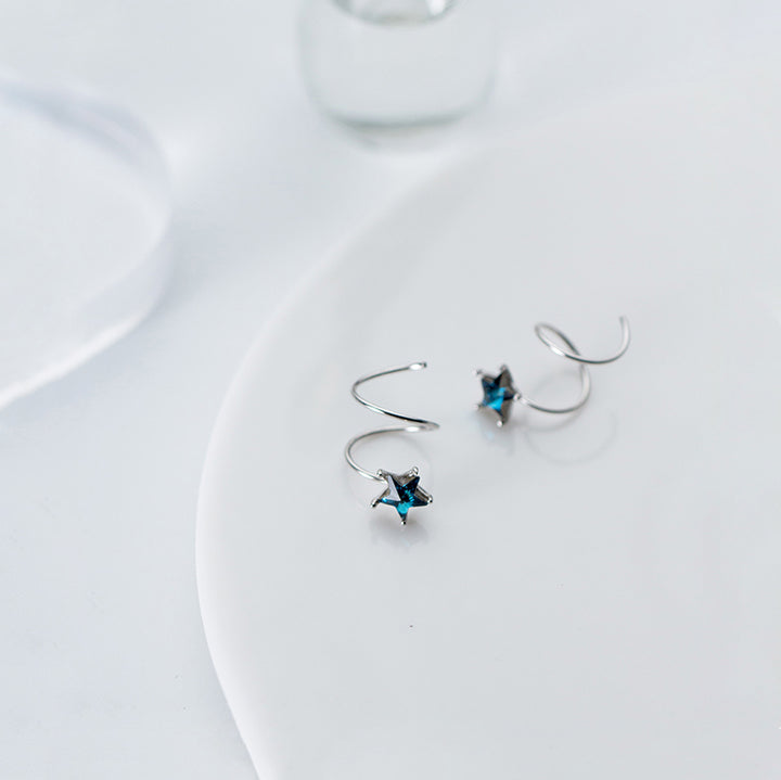 Une paire de boucles d'oreille spirale grimpante avec une étoile en strass bleu - Femme - Argent 925.