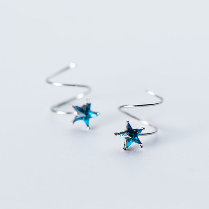 Une paire de boucles d'oreille spirale grimpante avec une étoile bleue en strass - Femme - Argent 925. Une fusion parfaite de modernité et de poésie pour un look distinctif et original.