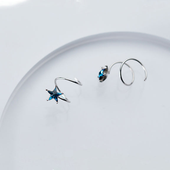 Une paire de boucles d'oreille spirale grimpante avec étoile strass bleu en argent 925 - Femme. Évoque un ciel étoilé autour de l'oreille.