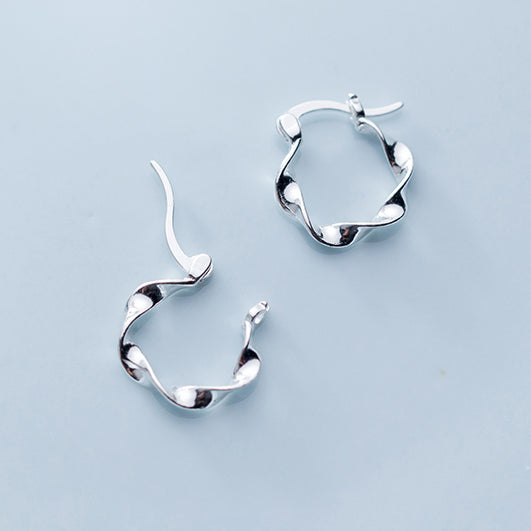 Boucle d'oreille créole torsadée en argent 925, élégante et audacieuse. Idéale pour chaque occasion, cette paire de boucles d'oreille légère offre une touche unique de sophistication.