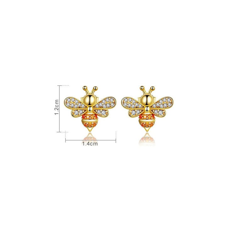 Une paire de boucles d'oreille en forme d'abeille dorée avec des strass orange et des ailes délicates ornées de strass transparents. Un bijou en argent 925 plaqué or, idéal pour ajouter une touche scintillante et raffinée à n'importe quelle tenue féminine. Dimensions : 1,2 x 1,4 cm, poids : 1,9 g.