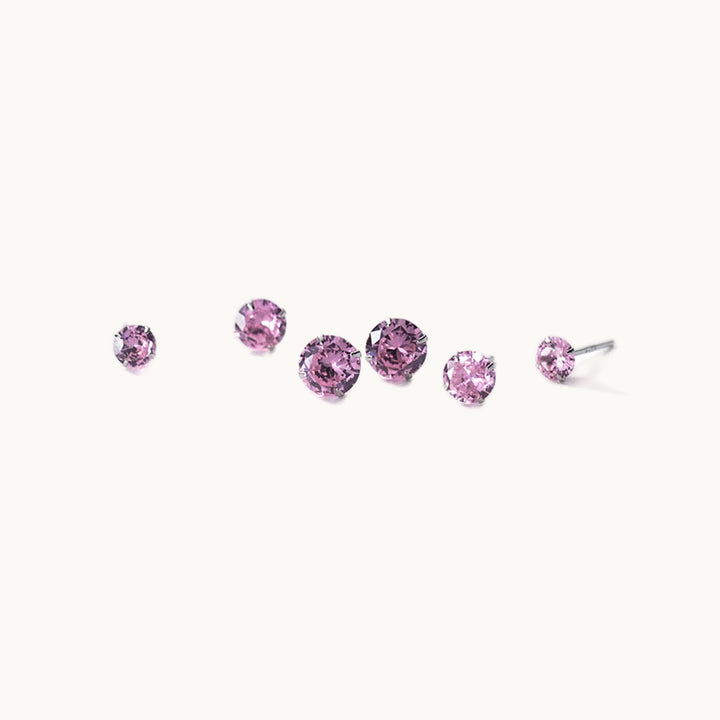 Ce sont des boucles d'oreille diamant violet de différents diamètres. La tige est en argent. 