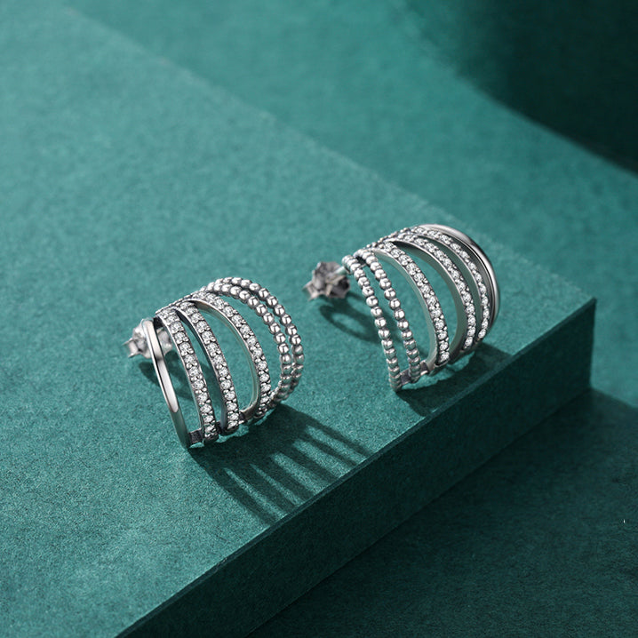 Boucle d'oreille anneaux multiples strass - Femme - Argent 925. Élégantes boucles d'oreilles en argent ornées de multiples anneaux, perles métalliques et éblouissants strass. Un design moderne et raffiné pour un éclat captivant.