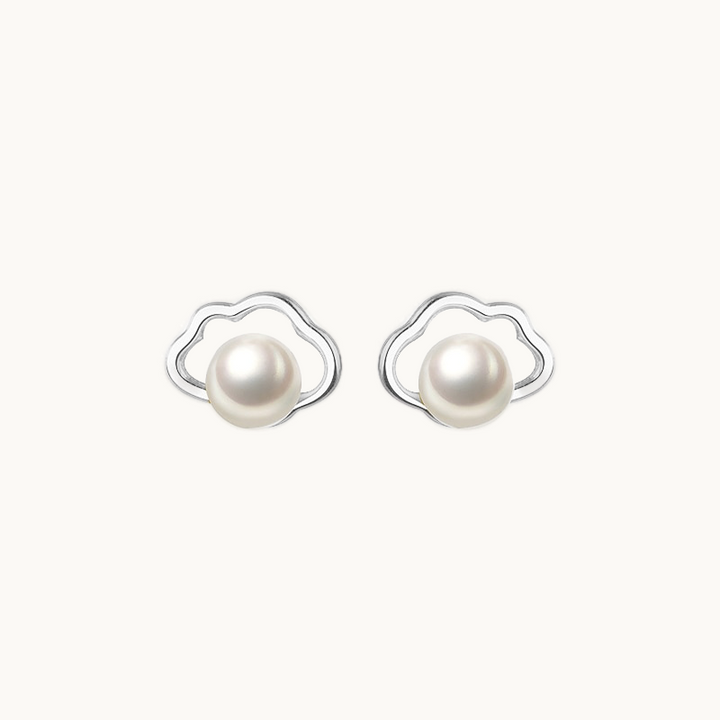 Une paire de boucles d'oreilles est exposée devant un fond beige.  Ce sont des nuages dans lesquels se trouvent une perle. Elles sont en argent 925.