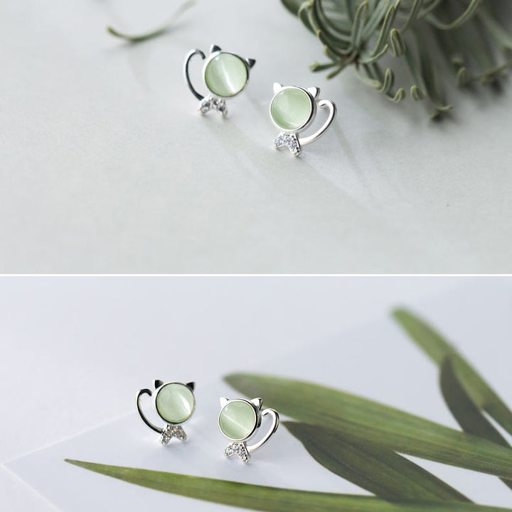 Boucle d'oreille chat argent 925, pierre cristal vert et strass - Femme. Élégance féline avec une touche de brillance, ces boucles d'oreille en argent 925 représentent un chat délicat avec une tête accentuée par un cristal vert clair et un corps scintillant de strass de zirconium.