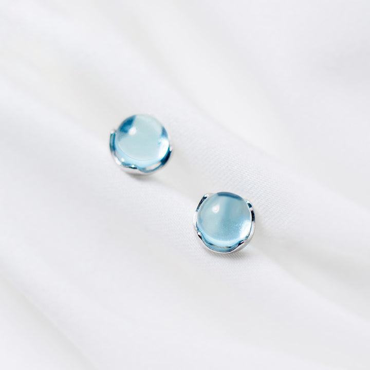 Boucle d'oreille ronde cristal bleu clair - Femme - Argent 925. Élégantes boucles d'oreille avec un cristal bleu ciel captivant, encadrées d'argent finement travaillé. Un bijou intemporel pour les amoureuses de la couleur.