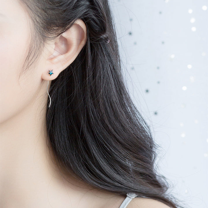 Boucle d'oreille pendante femme en argent 925 avec étoile et lune dépareillées, ornées de diamants de zirconium bleu saphir.