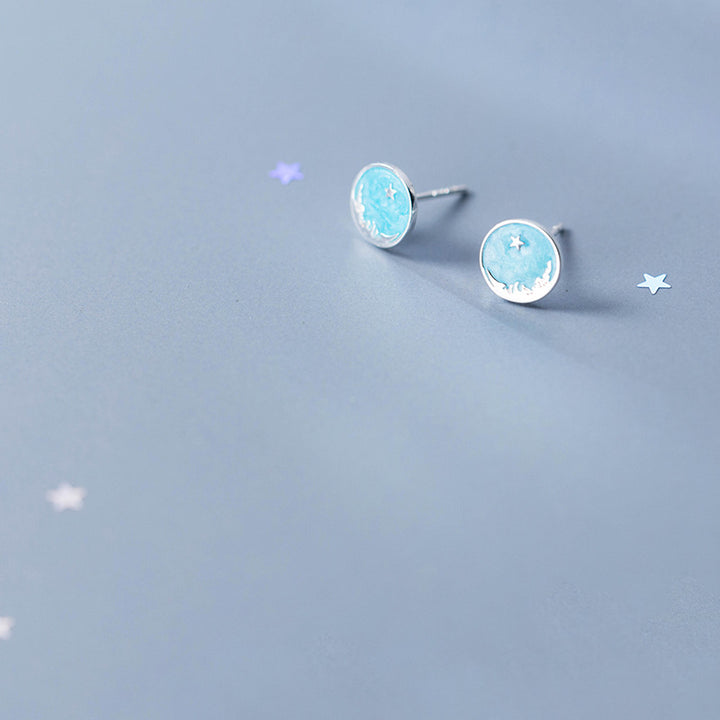 Boucle d'oreille ronde bleu ciel étoile en argent 925 pour femme. Évoque la sérénité d'un ciel nocturne étoilé avec une touche d'éclat subtil. Dimensions : 0,8 x 0,8 cm.