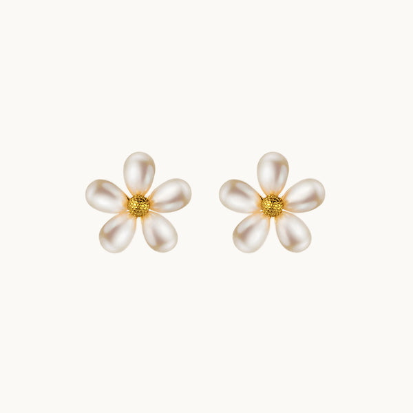 Une paire de boucles d'oreilles est exposée devant un fond beige.  Ce sont des fleurs. Les pétales sont en perles et le coeur de la feur en argent 925 plaqué or.