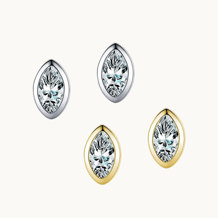 Deux paires de boucles d'oreilles sont exposées sur un fond beige. Ce sont des boucles d'oreille en forme d'amande. Elles sont ornées d'un diamant de zirconium. Il y a une paire en argent 925 et une en argent 925 plaqué or. 