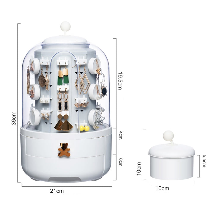 Un présentoir rotatif à 360° pour boucles d'oreille avec boîte de rangement. Compartiment transparent pour admirer vos bijoux en un coup d'œil. Deux tiroirs charmants, dont un orné d'un ourson doré. Élégance et fonctionnalité réunies.