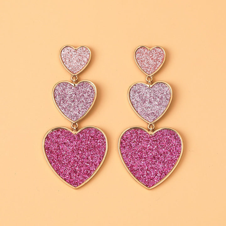 Boucle d'oreille pendante longue trio coeurs pailletés roses - Femme: un magnifique trio de cœurs superposés, reflétant une nuance de rose distincte, avec une finition dorée pour une allure élégante.