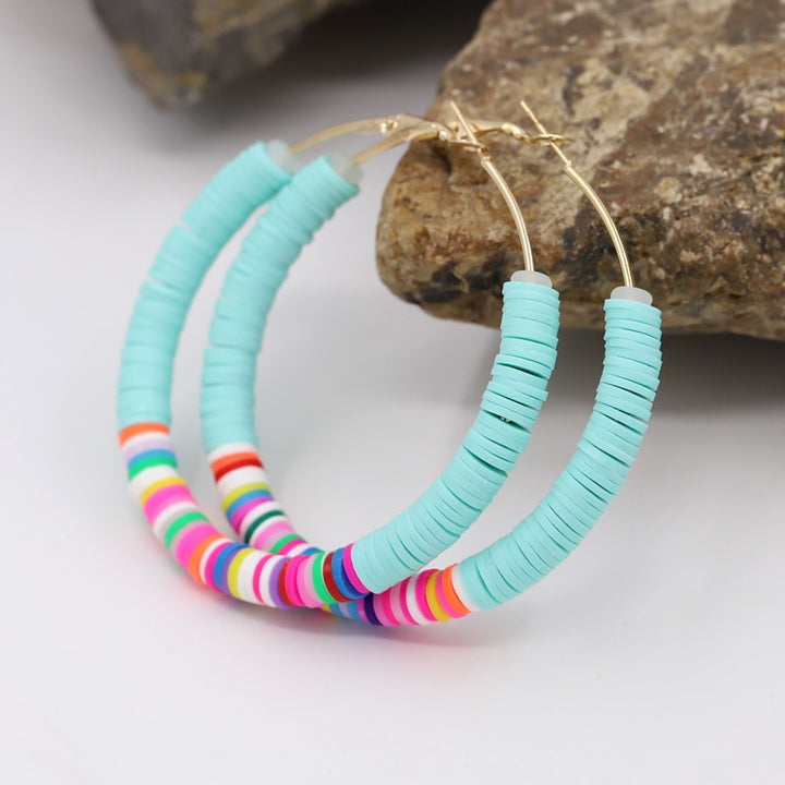 Une paire de boucles d'oreille créoles avec des anneaux plats colorés en argile - Enfant. Parfait mélange entre amusement et élégance pour démarquer votre petite fille avec style. 12 nuances étincelantes pour égayer sa journée. 65 x 65 mm, 12,5 g.