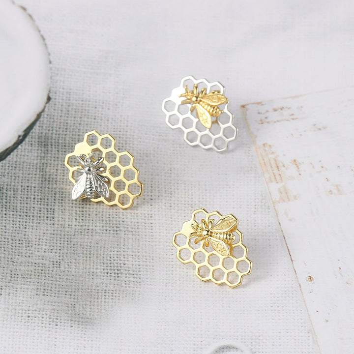 Boucle d'oreille abeille nid d'abeille - Femme: motifs de nid d'abeille et d'abeille en or et argent, élégance naturelle et intemporelle. Dimensions: 1,8 x 1,4 cm, poids: 3,5 g. Matériau: Cuivre.