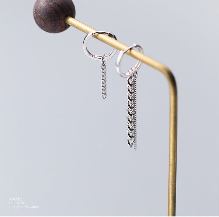 Boucle d'oreille asymétrique en argent 925 avec anneaux et chaînes pendantes de tailles différentes pour une dynamique unique.
