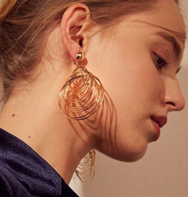 Boucle d'oreille pendante femme avec anneaux entrelacés en alliage de zinc. Élégance naturelle et sophistication pour toutes occasions.