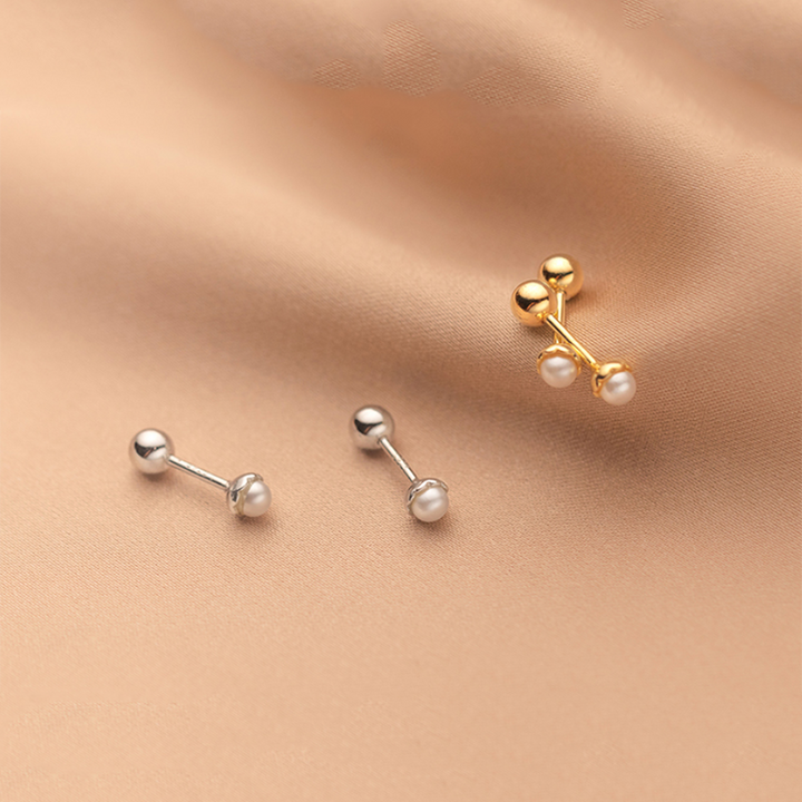 Une paire de boucles d'oreille minimalistes en argent 925 avec une délicate perle d'eau douce. Fermeture sécurisée en forme de boule métallique. Parfait pour une femme élégante.