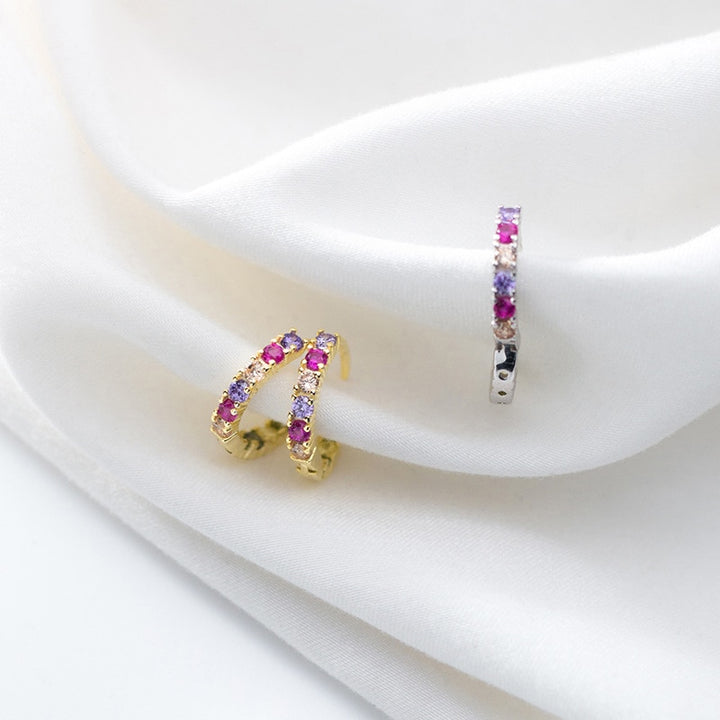 Une paire de boucles d'oreilles créoles en argent 925 avec des strass colorés - Femme - Argent 925 plaqué or. Des teintes roses, violettes et jaunes se marient harmonieusement pour offrir un éclat multicolore. Dimensions : 1,4 x 0,2 cm.