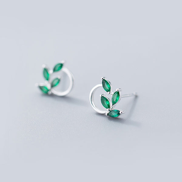 Une paire de boucles d'oreille rondes avec des pierres vertes, feuilles scintillantes en diamants colorés. Un choix parfait pour toutes occasions.