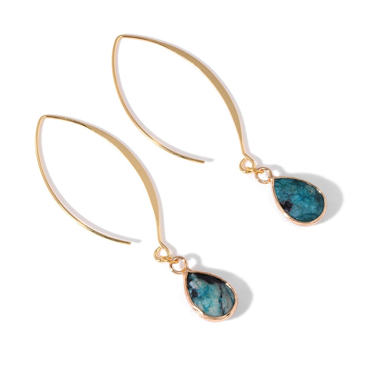 Une paire de boucles d'oreille pendantes en or avec pierre bleue - Femme. Design ovale doré avec pierre naturelle en forme de goutte pour une touche d'authenticité et de mystère. Dimensions : 13 x 7 mm.