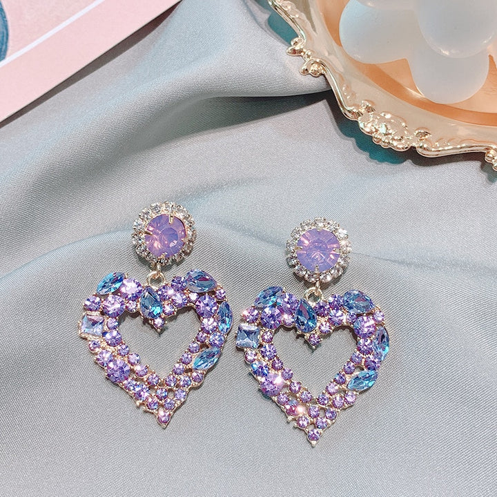 Boucles d'oreilles en forme de cœur violet et bleu, avec un gemme violet étincelant et un pendentif en forme de cœur. Parfait pour briller de mille feux.