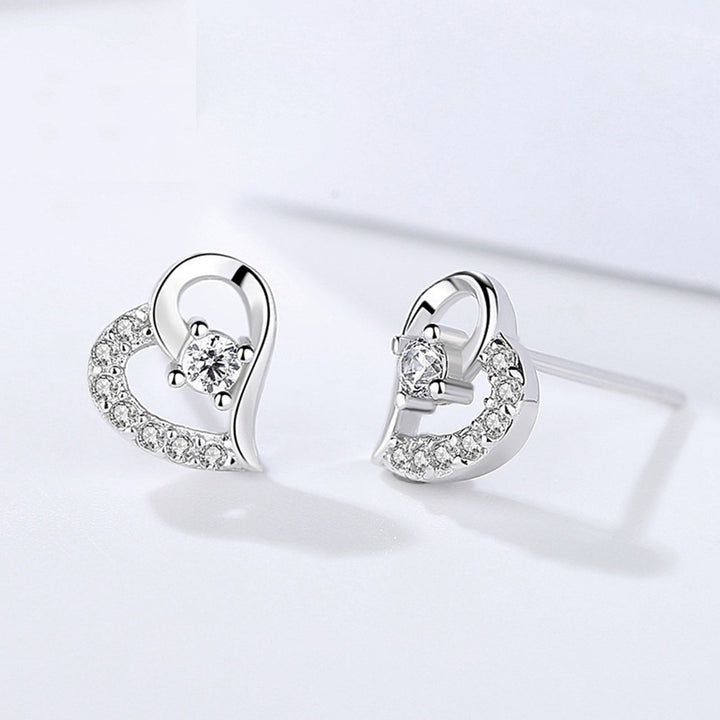 Boucle d'oreille coeur strass diamant - Femme - Argent. Élégantes boucles d'oreilles en argent avec strass scintillants et un diamant en cristal au centre. Un trésor pour votre collection.