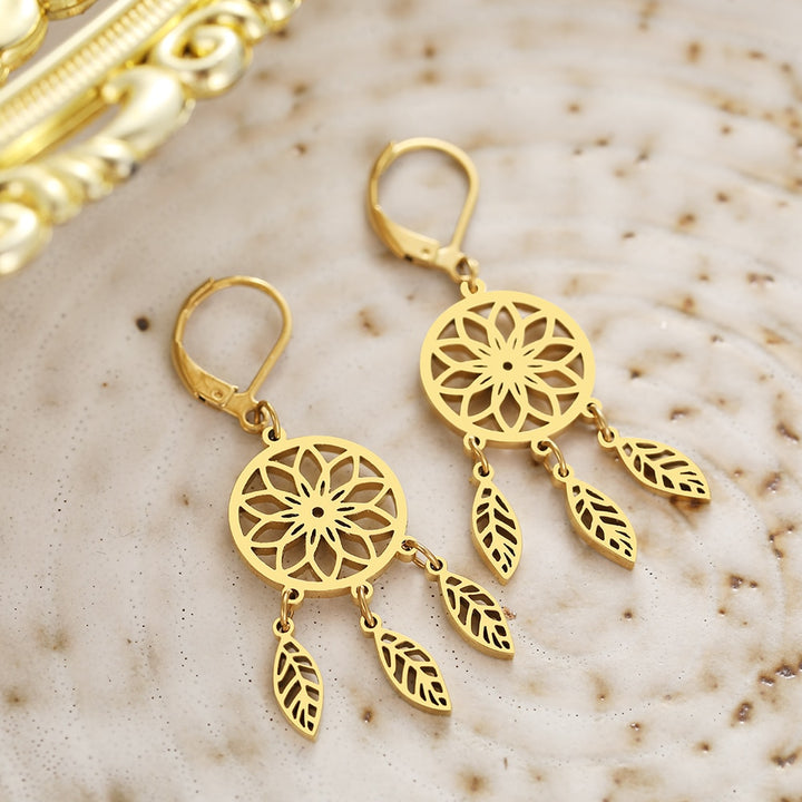 Une paire de boucles d'oreille pendantes attrape-rêve en acier inoxydable plaqué or, représentant des plumes délicates. Ajoutez une touche bohème raffinée à votre style féminin avec ces bijoux.