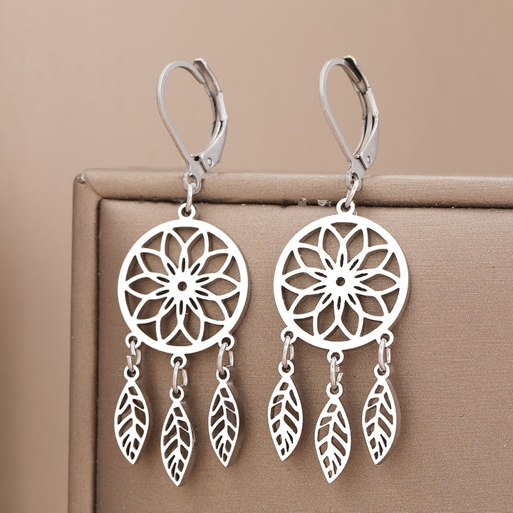 Une paire de boucles d'oreille pendantes en argent représentant un attrape-rêve avec des plumes. Ajoutez une touche bohème raffinée à votre style avec ces bijoux légers et protecteurs contre les mauvais rêves. Matériau : acier inoxydable plaqué or, argent. Pour femme.