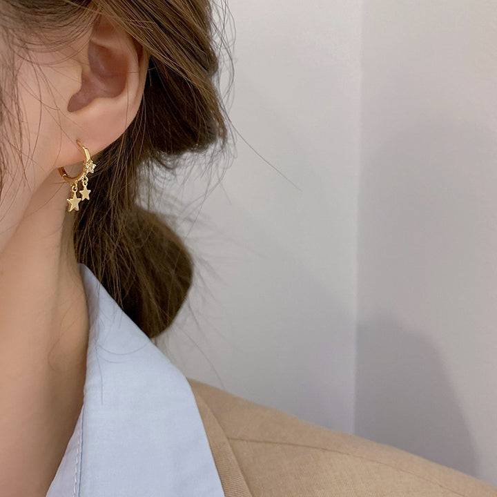 Boucle d'oreille dorée en forme d'anneau avec étoiles pendantes et strass - Femme. Élégance intemporelle et éclat moderne pour une touche d'éclat à votre tenue.