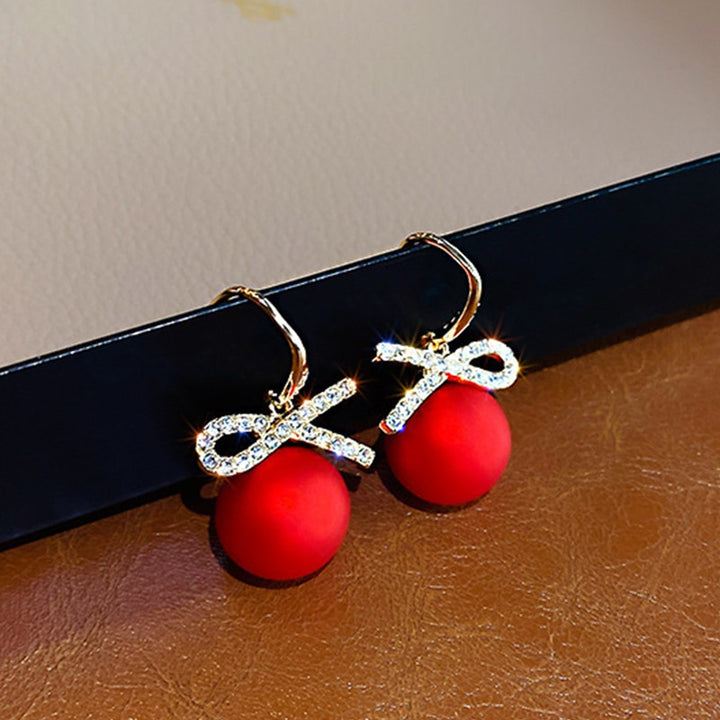 Boucle d'oreille pendante boule de Noël rouge avec nœud strass - Élégantes boucles d'oreille en alliage de zinc pour femme, parfaites pour les fêtes.