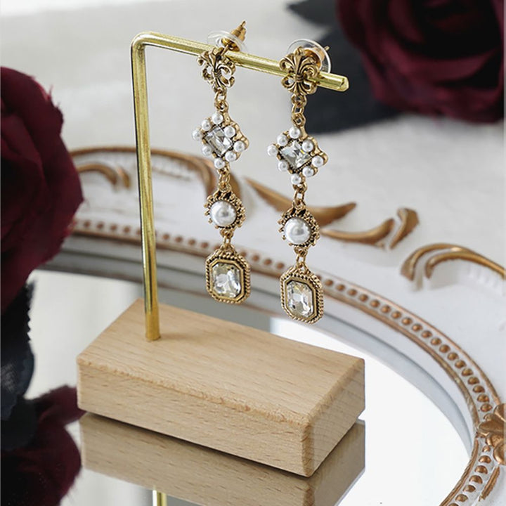 Présentoir support boucles d'oreille bois métal doré - Élégant support en bois et métal doré pour une paire de boucles d'oreille. Quatre modèles distincts avec formes variées pour mettre en valeur vos bijoux préférés.
