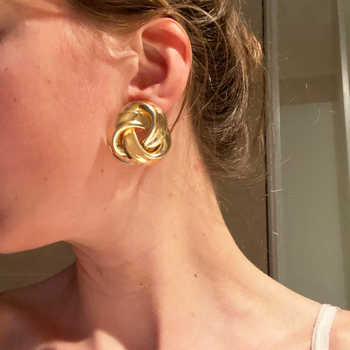 Boucle d'oreille ronde torsadée en alliage de zinc pour femme, reflétant la lumière avec élégance. Polyvalente et légère, elle sublime chaque jour.