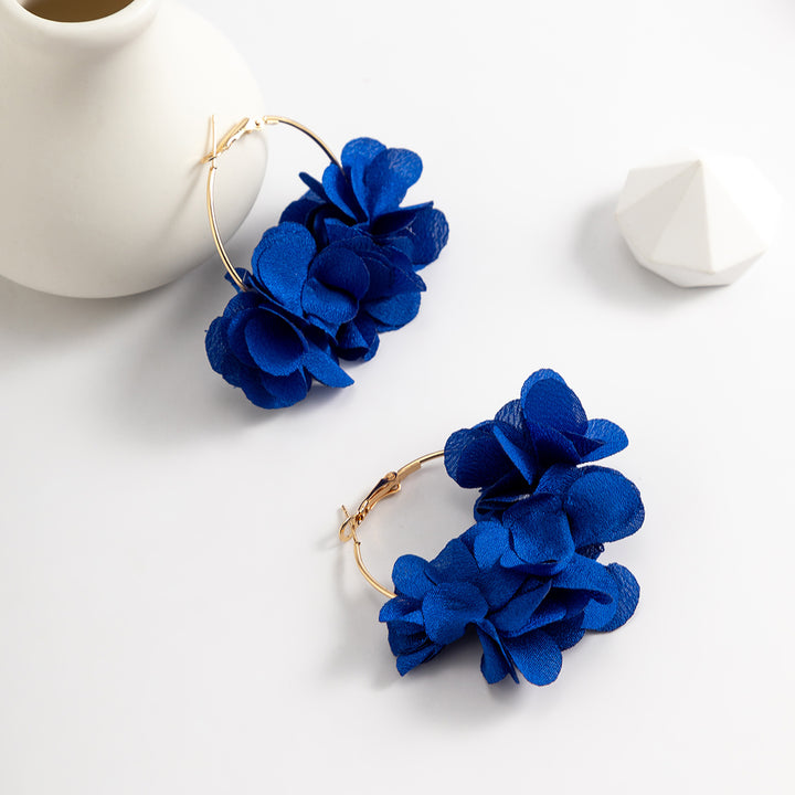 Une paire de boucles d'oreille créoles dorées avec de ravissantes fleurs en tissu suspendues. Ajoutez une touche florale délicatement féminine à votre tenue avec ces bijoux élégants et légers. Disponibles en six couleurs séduisantes. 1001 Boucles d'Oreille, site de ventes de boucles d'oreille.