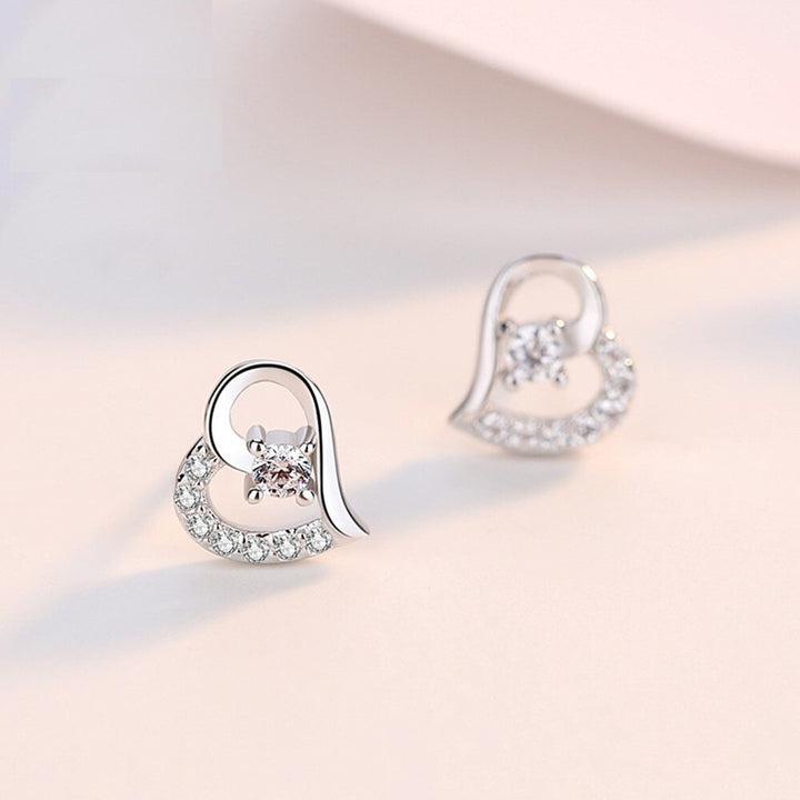 Boucle d'oreille coeur strass diamant - Femme - Argent: une paire de boucles d'oreilles en forme de coeur avec un diamant en cristal scintillant. Un trésor d'élégance intemporelle pour votre collection.