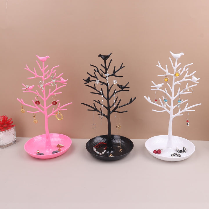 Un présentoir pour boucles d'oreille en forme d'arbre avec des oiseaux perchés, ajoutant une touche rétro et colorée à votre espace.