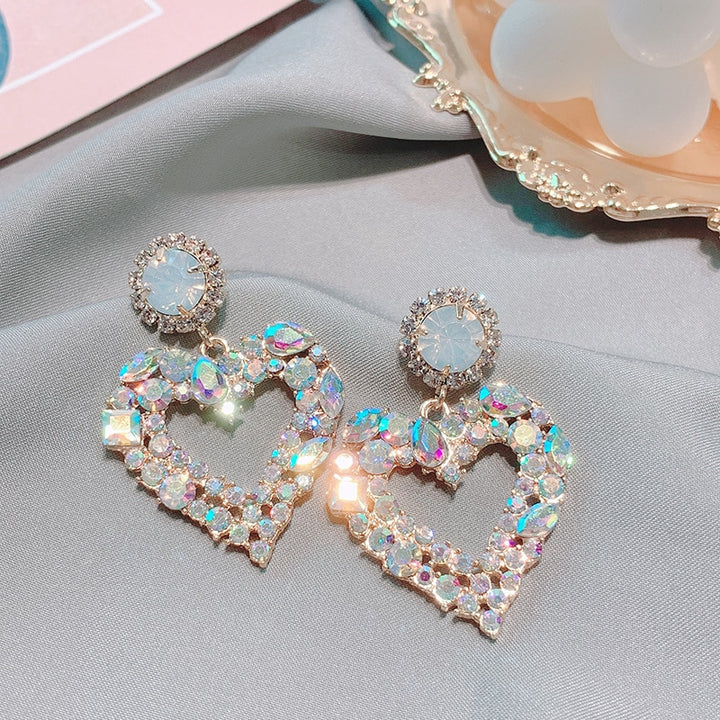 Une paire de boucles d'oreilles en forme de cœur avec un diamant et des strass étincelants - Femme