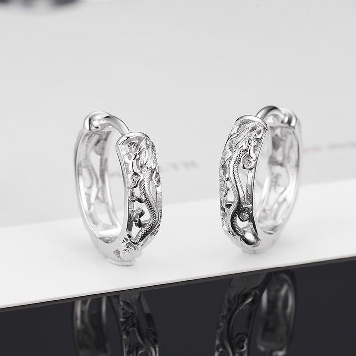 Boucles d'oreille homme argentées en forme de dragon ajouré, symbole de puissance et de mystère. Parfaites pour ajouter une touche audacieuse à votre tenue.