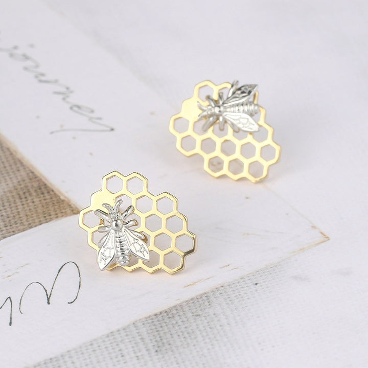 Boucle d'oreille abeille nid d'abeille - Femme, une paire de boucles d'oreille avec un motif de nid d'abeille et une abeille en or et argent. Élégance naturelle et intemporelle.